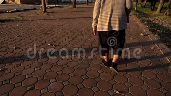 在公园里老年妇女用手杖走路的腿慢运动视频的预览图