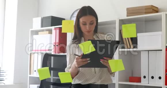 女商人站在玻璃墙附近的文件里做笔记视频的预览图