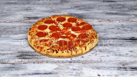 特写手在桌子背景下从木盘中取出一片热的美味意大利披萨视频的预览图