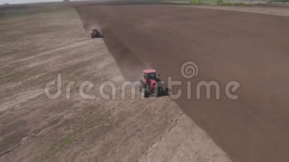 两辆拖拉机朝相反的方向行驶并耕种土地农用拖拉机耕田视频的预览图