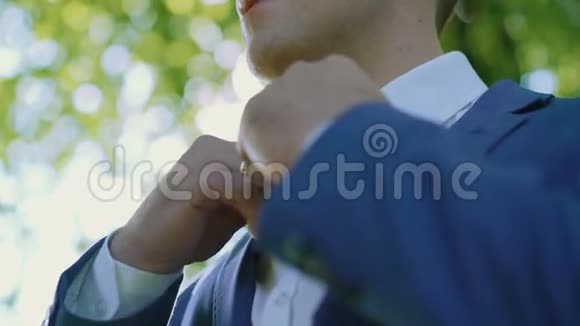 绿光森林中白色衬衫上的男士双手正确的结婚礼服视频的预览图