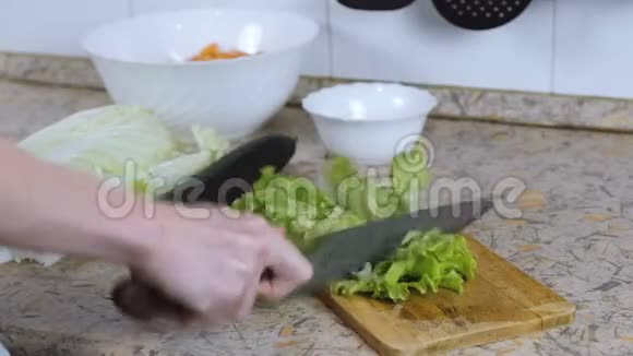 无法辨认的女人在厨房桌子上的砧板上切生菜敲刀把手举起来视频的预览图