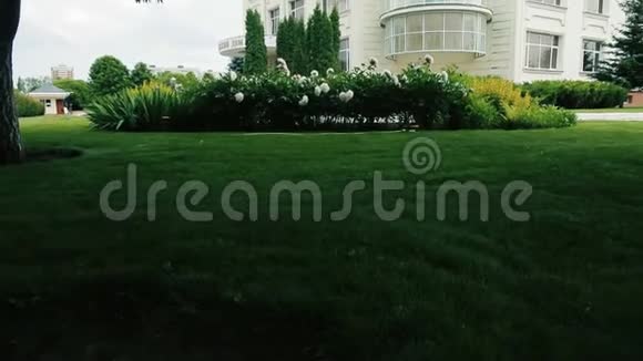 美丽的白色两层房子风景如画的绿色花园视频的预览图