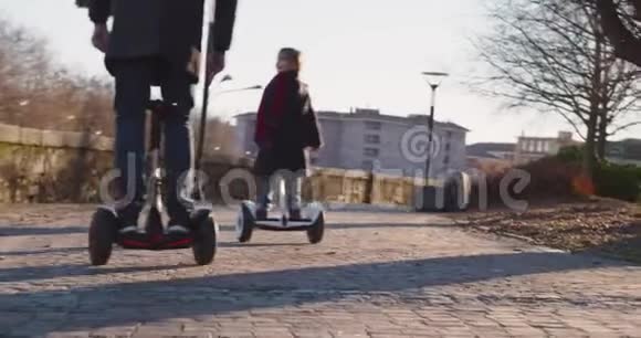 女儿的孩子和她的父亲在城里骑着西格威现代未来运输技术积极的家庭公园人行道视频的预览图