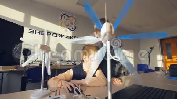 两个男孩学习风力涡轮机的小模型视频的预览图