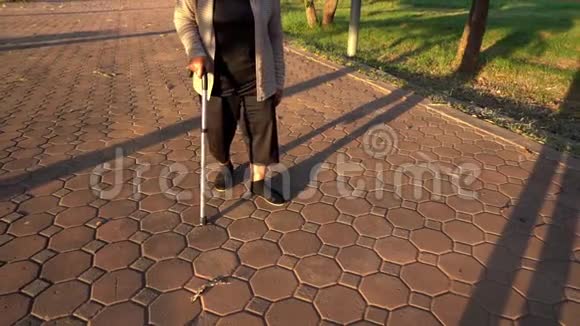 在公园里老年妇女用手杖走路的腿慢运动视频的预览图