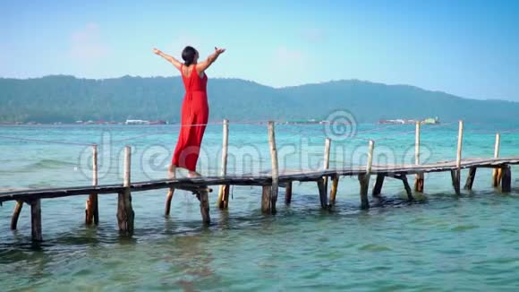 穿着红色长裙走在码头上的美女PhuQuoc岛那个女人在一个码头上花了很多钱视频的预览图