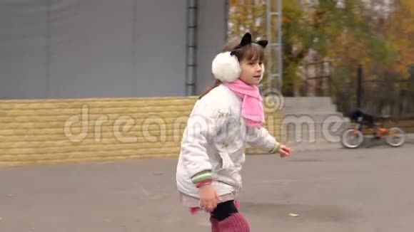 女孩骑着旱冰车在秋天的公园里视频的预览图