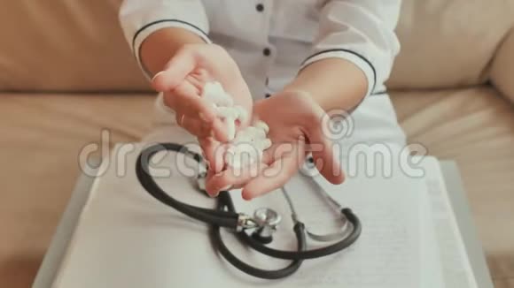 一位年轻的女医生把白色的药丸从手到手视频的预览图