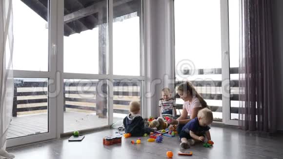 快乐的孩子们一起玩儿童概念在私人住宅中的儿童坐在地板上的全景窗和视频的预览图