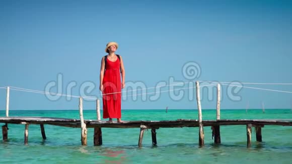 穿着红色长裙走在码头上的美女PhuQuoc岛这名女子在木墩上背着一个背包视频的预览图