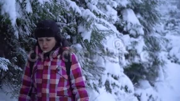 一个年轻的女人独自走过一片雪林年轻漂亮的游客偷偷地溜过雪地她环顾四周视频的预览图