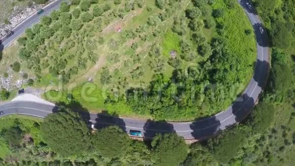 汽车在树木和灌木丛之间蜿蜒的道路上行驶鸟瞰意大利视频的预览图