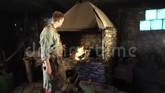 男铁匠在烧火铁匠在铁砧上锻造马蹄铁全高清视频的预览图
