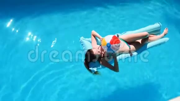 千禧一代女孩在游泳池节日酒店海滩上漂浮夏天戴着墨镜微笑晒太阳视频的预览图