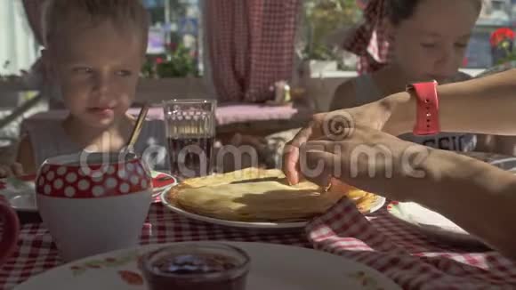 两个男孩正在阳台上吃煎饼作为早餐视频的预览图