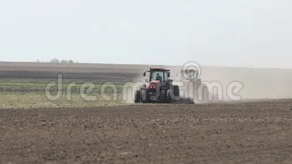 两辆拖拉机朝相反的方向行驶并耕种土地农业拖拉机耕田视频的预览图