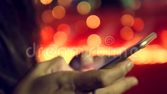 女性手在智能手机上发短信背景上有圣诞树灯4K视频的预览图