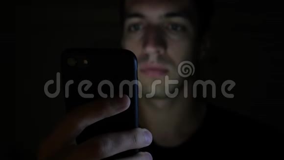 夜间使用智能手机上网或查看社交网络的年轻人特写视频的预览图