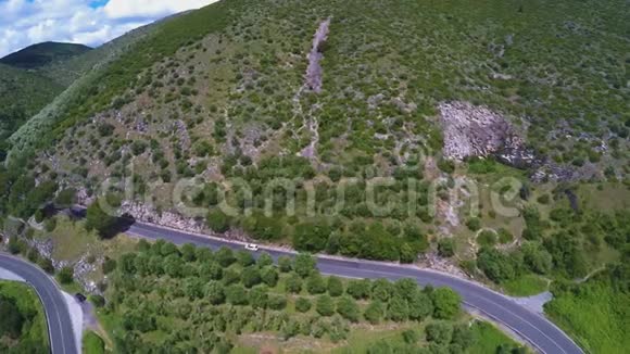 在蜿蜒的山路上行驶的汽车草山的鸟瞰图视频的预览图