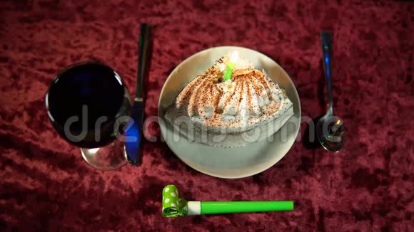 有人在节日背景的蛋糕里熄灭了燃烧的蜡烛视频的预览图