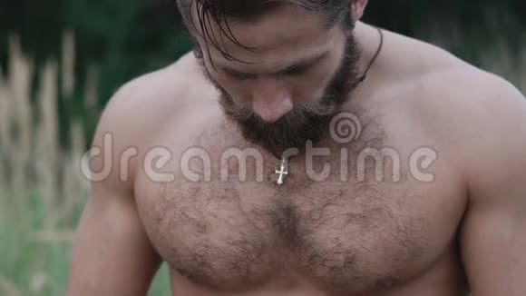 草原上英俊留胡子的运动员强烈注视镜头的肖像视频的预览图