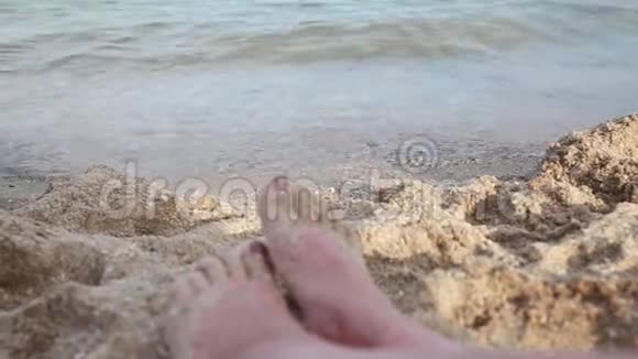 海滩上女孩的腿海上日落海浪海风沙滩视频的预览图