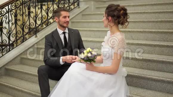美丽的新婚夫妇在别致的昂贵的室内台阶上摆姿势视频的预览图