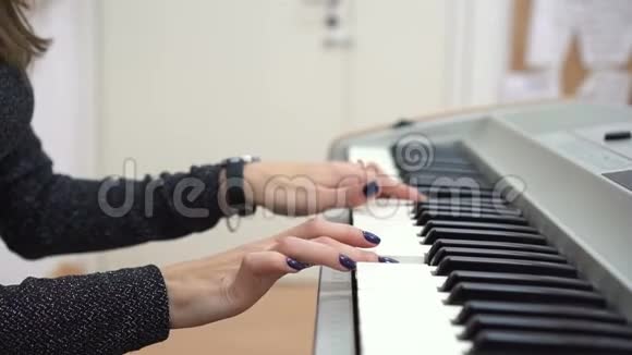 弹钢琴或合成乐器时女人的手视频的预览图