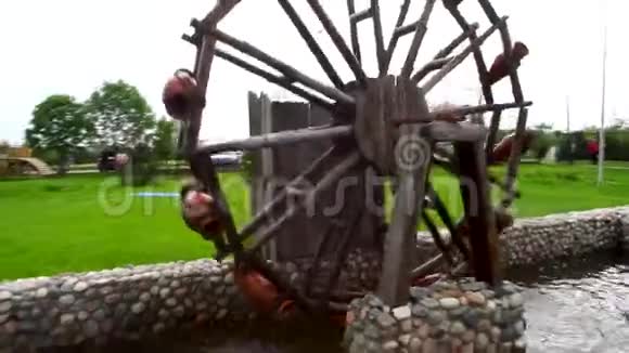 乡村院子里的旧木水厂小木水磨在一个小池塘里旋转在花园里装饰视频的预览图