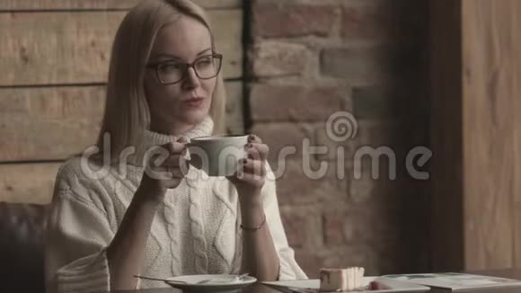 坐在咖啡馆里的女人一边看一边喝咖啡视频的预览图