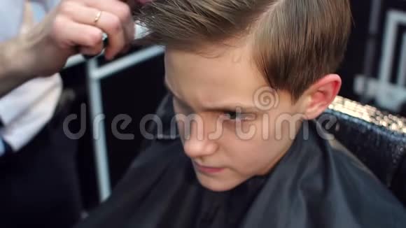 理发师在理发后给男孩梳头视频的预览图