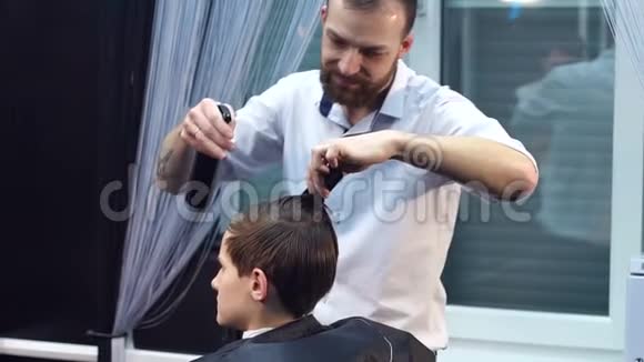 男理发师在青少年头发上喷水视频的预览图