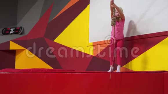城市中一个现代儿童的快乐童年游乐园里的女孩骑着绳子视频的预览图