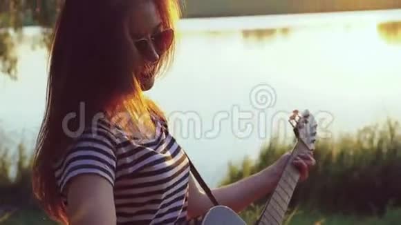少女在湖边弹吉他的肖像4k视频的预览图