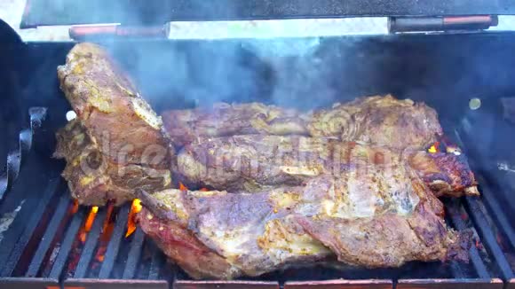 烤猪肉牛排在烤架上旋转肉串把烧烤的食物烤熟视频的预览图