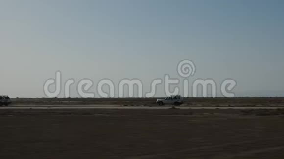 萨哈拉的越野车在沙地公路上行驶的越野车视频的预览图