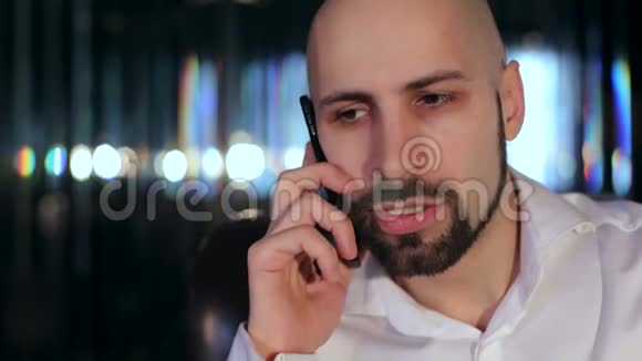 严肃的胡子男人在电话特写镜头上说话视频的预览图