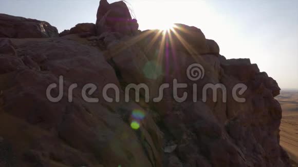 清晨阳光洒在岩石山上背景是沙漠中的沙丘视频的预览图