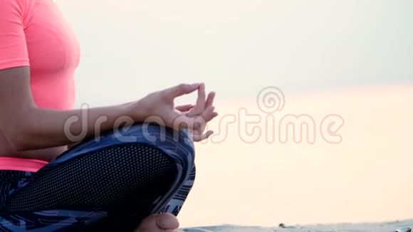 健康的年轻美女在沙滩上海边河边黎明时分黎明时分练习瑜伽视频的预览图