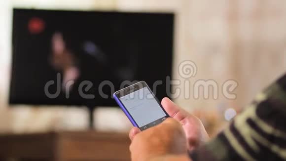老人坐在电视机旁的皮椅上拿着电话男人打字短信和看照片关门视频的预览图