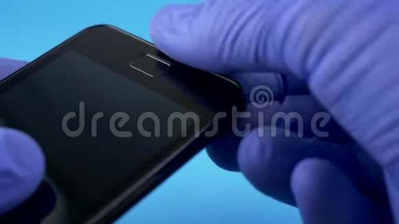 戴着黑色智能手机的蓝手套技师视频的预览图