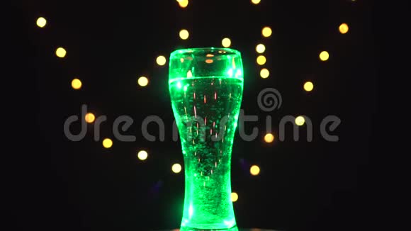 绿光下的一杯水在旋转绿色鸡尾酒酒吧概念视频的预览图