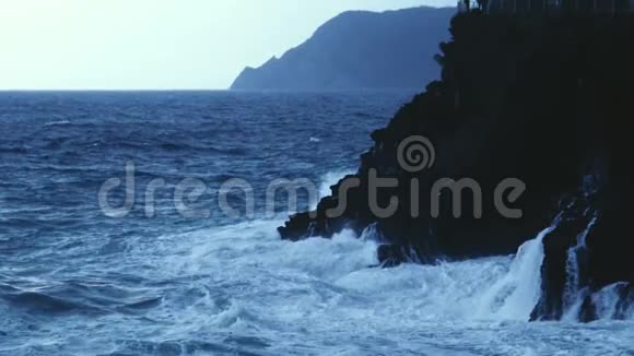 汹涌澎湃的海浪溅落在岩石峭壁上缓缓地移动视频的预览图