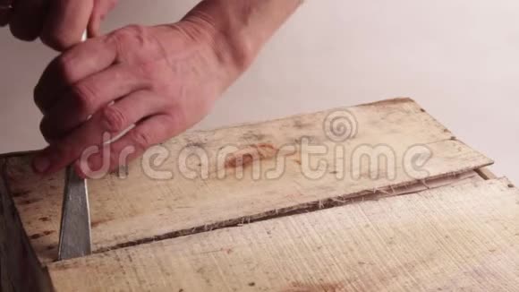 特写镜头男手用宽大的螺丝刀或其他安装工具打开木箱破了第一块木板光线背景视频的预览图