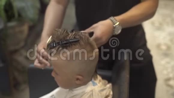 理发店用理发机理发的小男孩用电器把男孩的发型贴紧视频的预览图