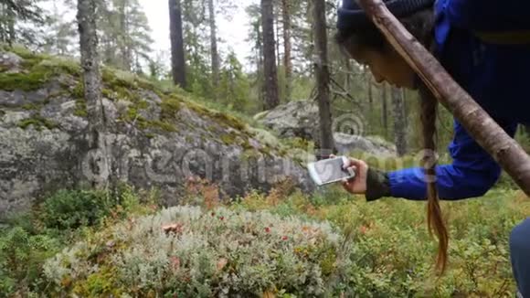 年轻的混合赛徒步女用手机拍摄绿苔生活方式慢动作4K镜头视频的预览图