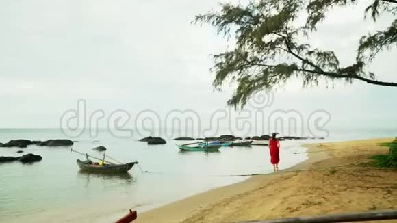 越南阳光明媚的一天那个女人沿着海岸的海洋走视频的预览图