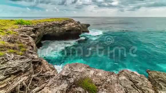 蓝绿色的海洋中的奇妙的波浪多云的天空环绕着努克宁安岛的悬崖视频的预览图