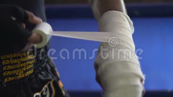 训练前摔跤手用弹力绷带小心地将受伤的手臂收卷视频的预览图